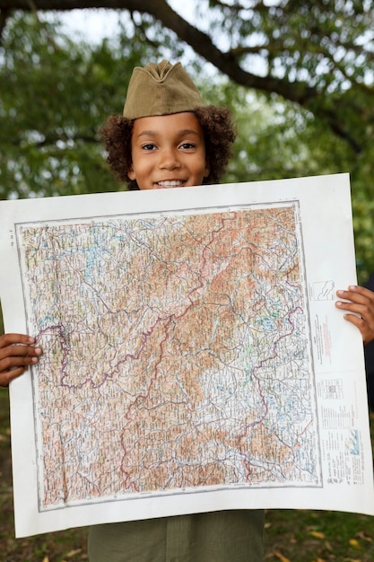 Free photo front view boy scout holding map