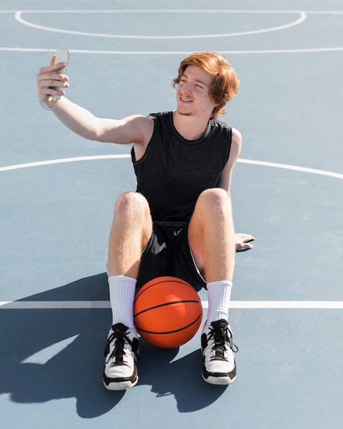 Foto gratuita vista frontale del ragazzo che prende un selfie