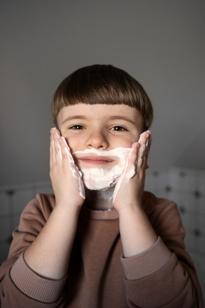 シェービングクリームを使用した正面図の少年