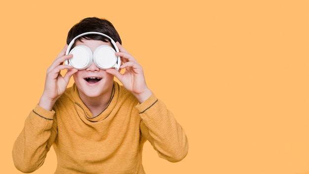 Free photo front view of boy with headphones with copy space