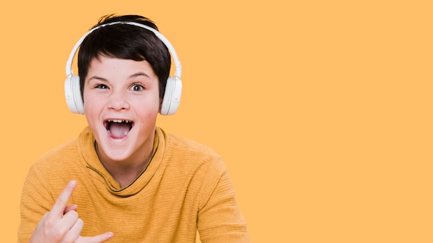 Free photo front view of boy with headphones with copy space