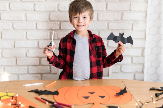 Free photo front view of boy with paper bat