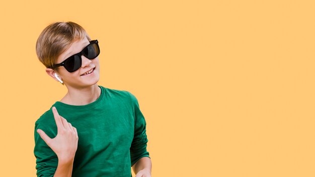 Front view of boy with sunglasses and copy space