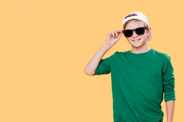 Free photo front view of boy with sunglasses and copy space