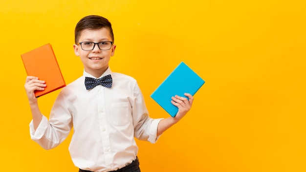 Foto gratuita ragazzo di vista frontale con due libri