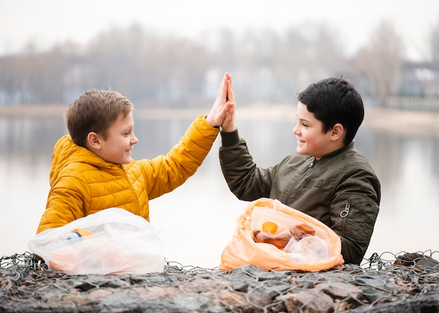 Free photo front view of boys giving high five