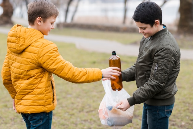 Front view of boys with plastic bag