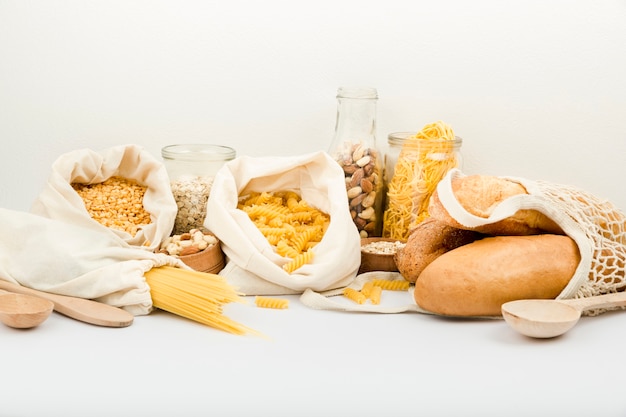 Вид спереди на хлеб в многоразовой сумке с макаронами и орехами