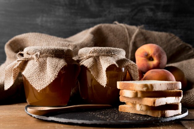 Front view of bread slices with jars of jam