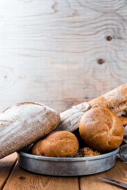 Free photo front view of bread on tray on wooden table