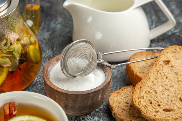 正面図朝食デスクパン蜂蜜と暗い表面のお茶の朝のお茶