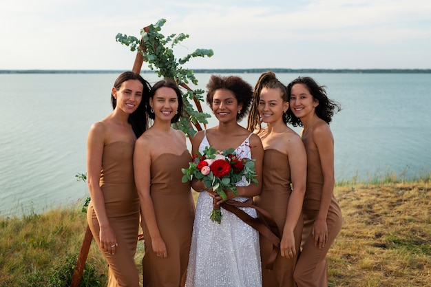 Впереди невеста и подружки невесты в природе