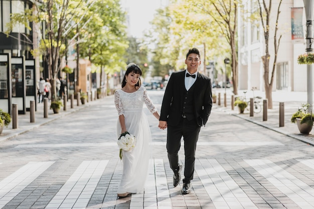 Vista frontale della sposa e dello sposo che camminano sulla strada