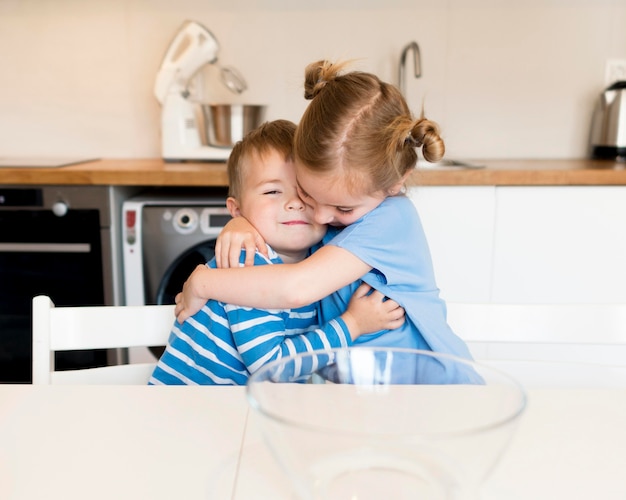 Front view of brother and sister hugging