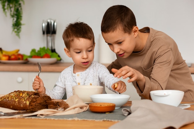 Free photo front view brothers with food at home