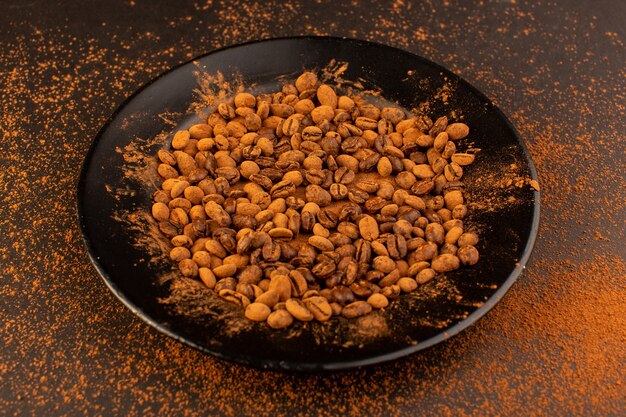 Вид спереди коричневые семена кофе внутри черной тарелки
