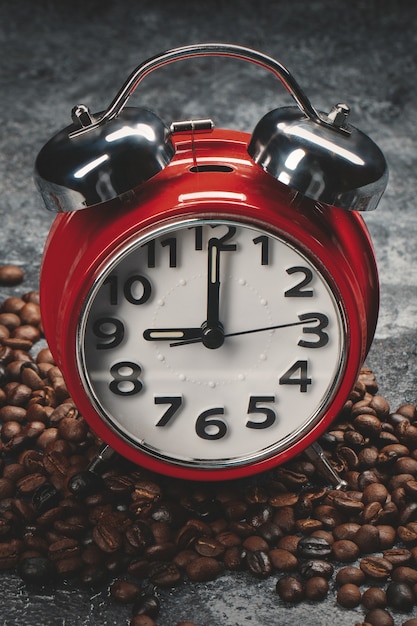 Free photo front view of brown coffee seeds with clocks dark wall