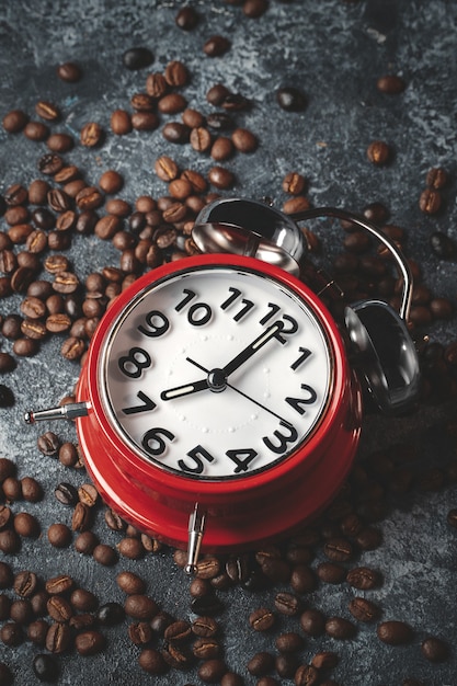 Front view of brown coffee seeds with red clocks dark surface