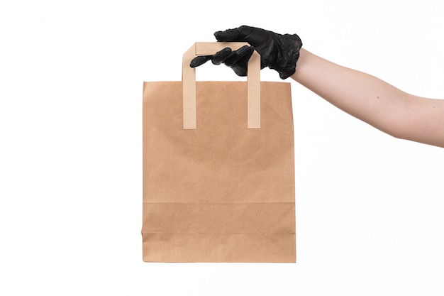 Free photo a front view brown paper package holding by female in black gloves job