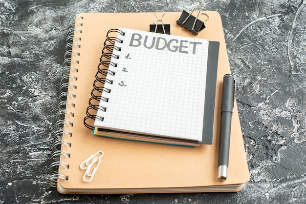 front view budget written note on notepad with pen on dark background