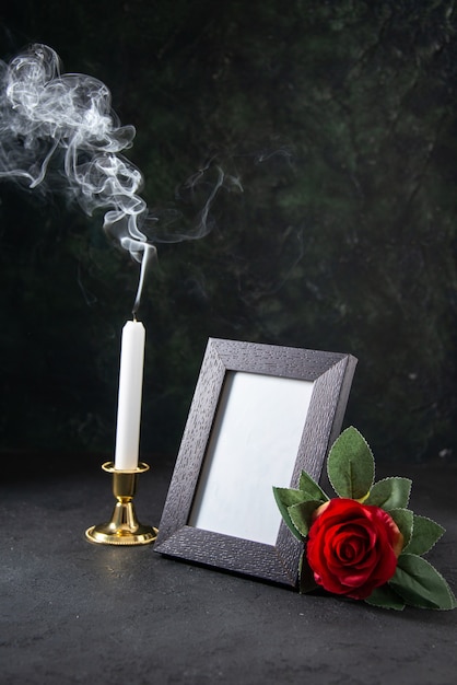 Free photo front view of burning candle with picture frame on dark surface