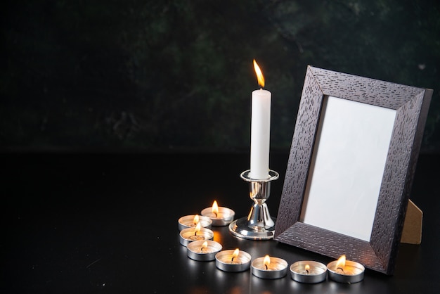 Front view of burning candles as memory for fallen on black surface