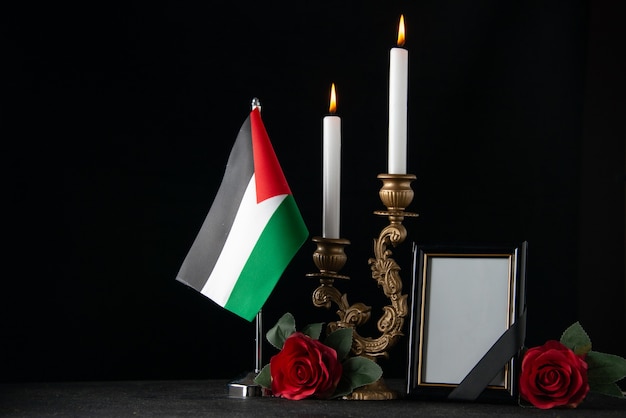 Free photo front view burning candles with palestinian flag and picture frame dark surface