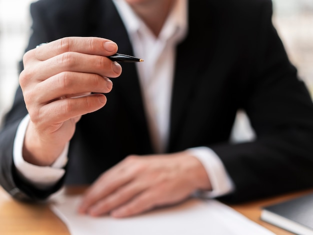 Front view business man holding pen