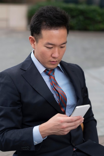 Вид спереди делового человека со смартфоном
