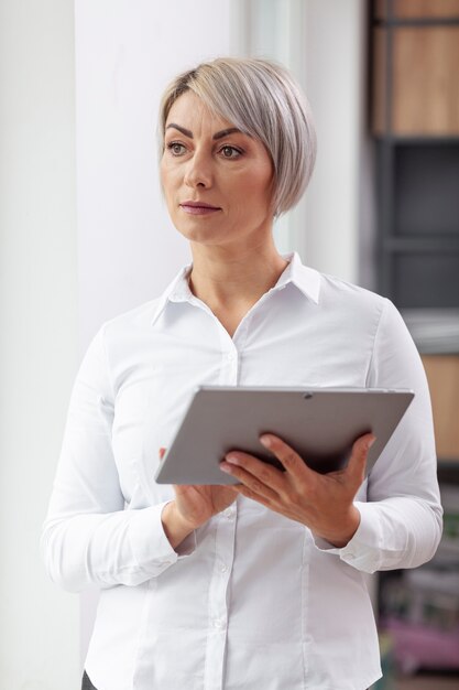 Front view business woman at office with tablet