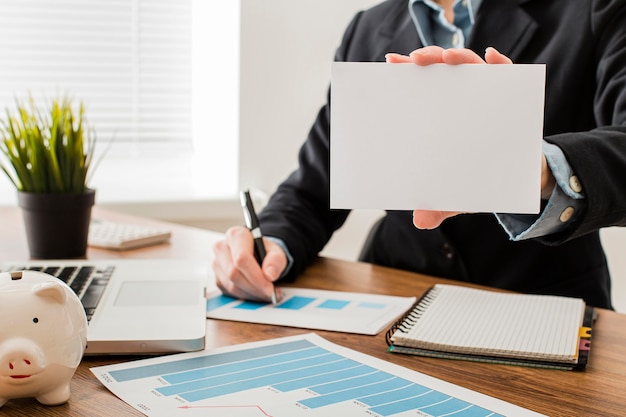 Front view of businessman at the office holding blank paper