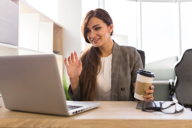 Free photo front view of businesswoman at desk having a video call