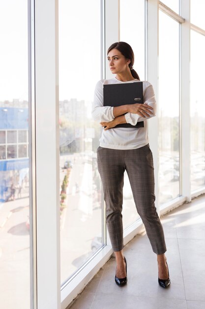 Front view of businesswoman holding binder