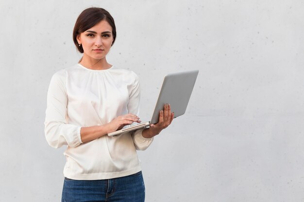 front view of businesswoman holding laptop outdoors