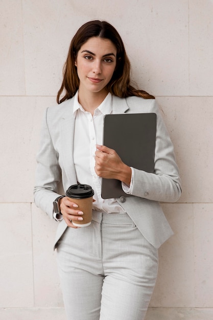 Front view of businesswoman holding tablet and coffee cup