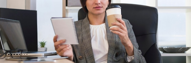 Free Photo front view of businesswoman in the office having coffee