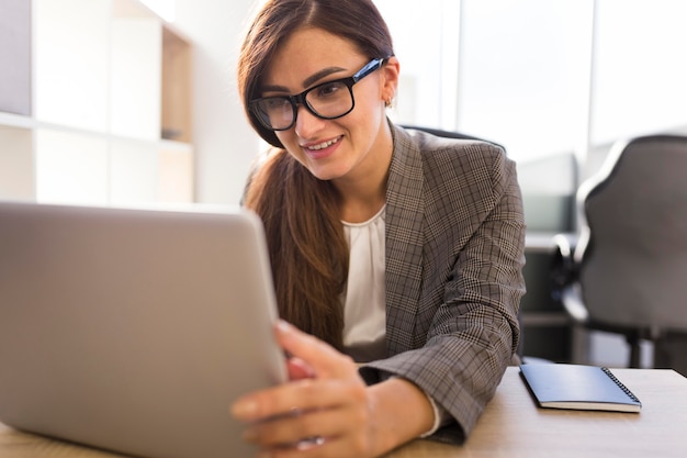 Free photo front view of businesswoman in the office working on laptop