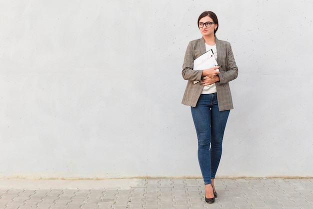 Front view of businesswoman posing with notepad outdoors