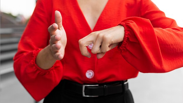 Front view of businesswoman using sign language outdoors at work