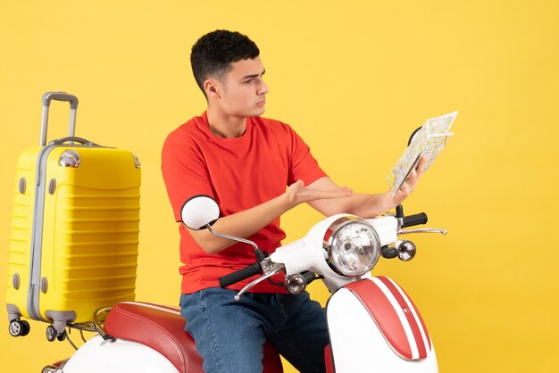 Front view busy young man on moped looking at map