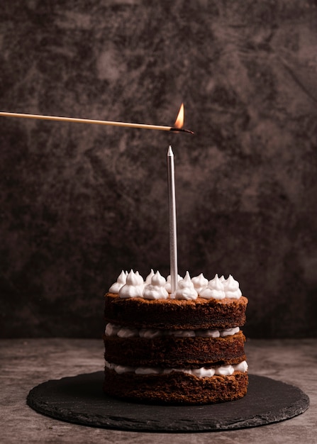 Вид спереди торта на сланце со свечой