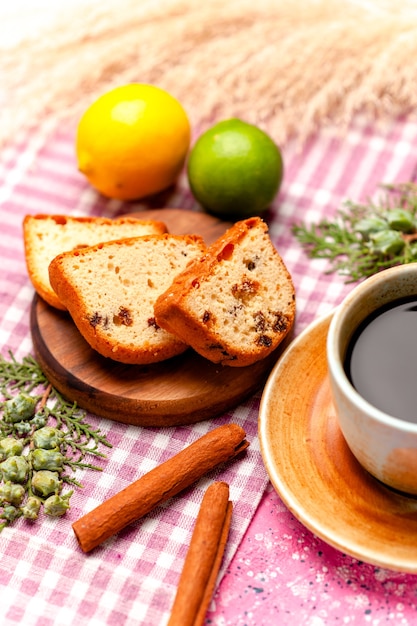 Foto gratuita fette di torta vista frontale con caffè e cannella sulla torta di superficie rosa cuocere i biscotti di zucchero della torta di colore del biscotto dolce