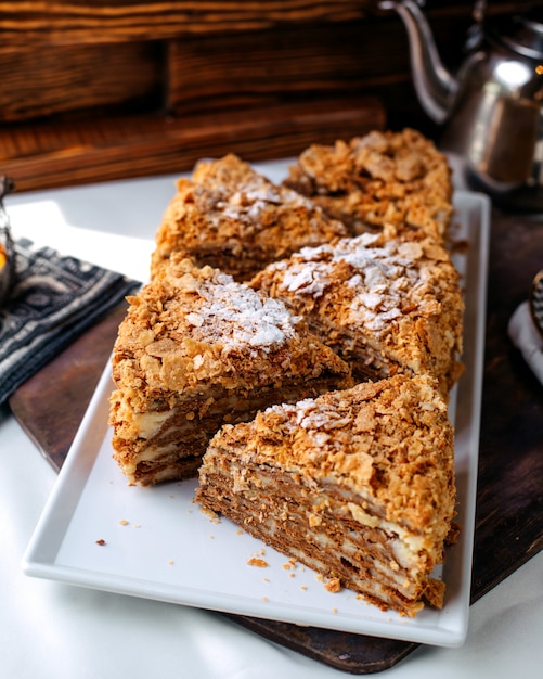 茶色の表面に白いプレート内でスライスした正面ケーキ甘いおいしい