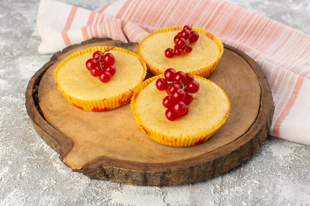 Front view of cake with cranberries yummy baked on the wooden board and grey surface