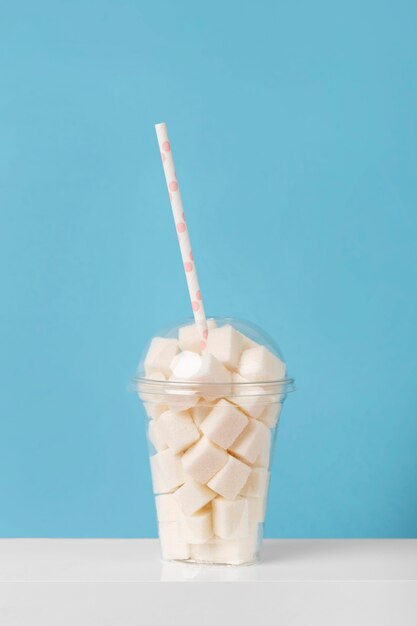 Front view of candies in plastic glass