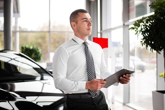 Front view car dealer male with clipboard