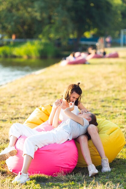 Front view carefree friends on colorful beanbags 