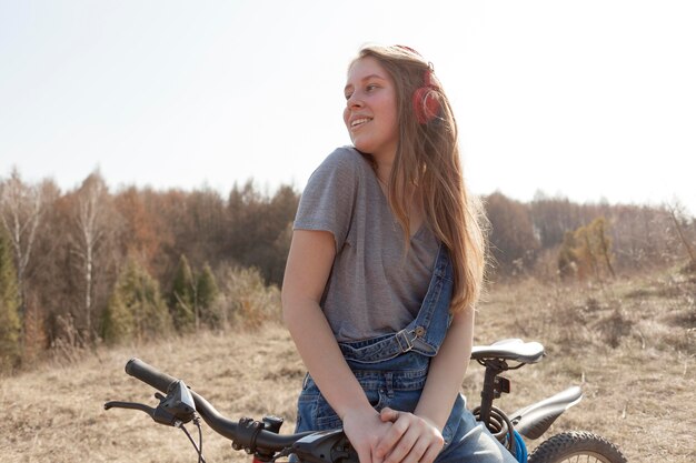 自然の中で自転車に屈託のない女性の正面図