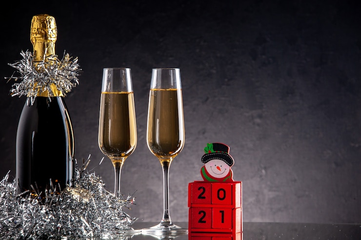Free Photo front view champagne in bottle and glasses wood blocks on dark surface