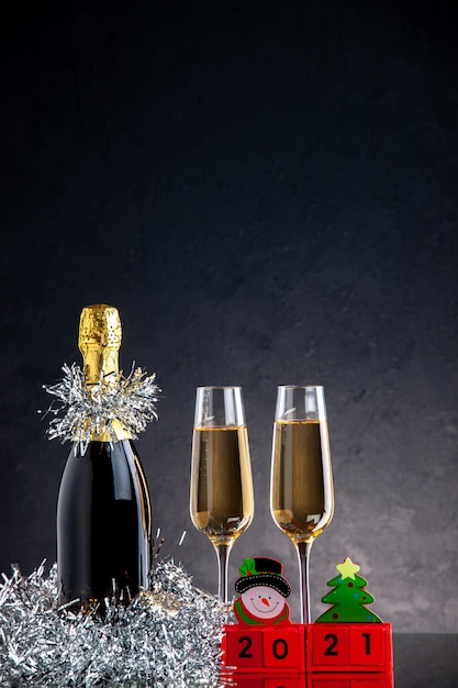 暗い表面にボトルとグラスの木製ブロックの正面のシャンパン